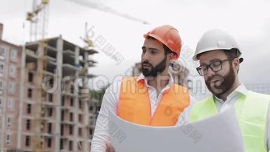 高层建筑施工现场或建筑工地，男建筑工程师与建筑师讨论.. 他们
